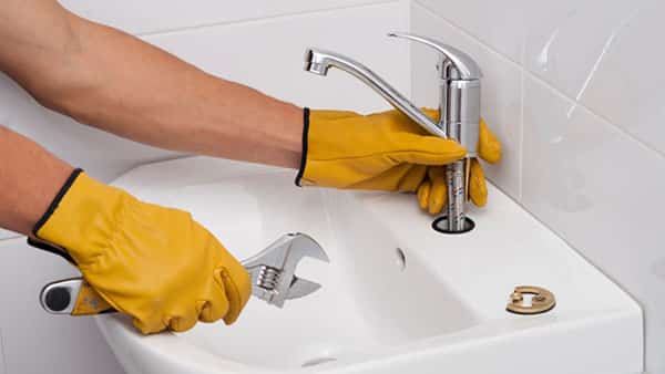 plumber installs a new faucet plumber installs a new tap