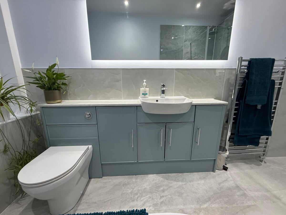 luxury bathroom with blue under sink storage and large mirror